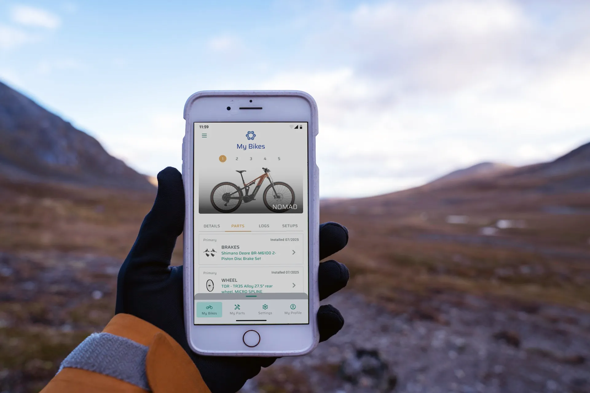 BikeBolts app displayed on a phone held up in a mountain landscape